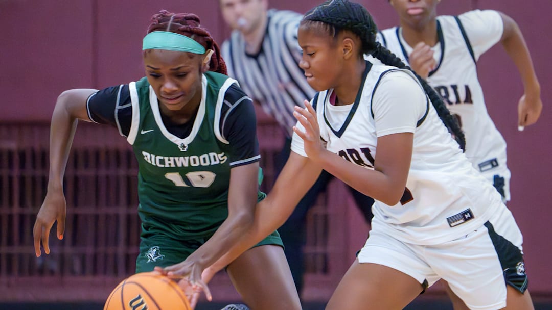 Peoria High’s Meriah Avant, right, tries to knock the ball away from Richwoods’ Keniya Todd in the first half of their high school basketball game Tuesday, Dec. 2, 2025 at Peoria High School. The Knights defeated the Lions 66-39.