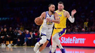 Golden State Warriors guard Stephen Curry moves to the basket against Los Angeles Lakers guard Luka Doncic.