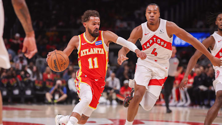 Oct 22, 2025; Atlanta, Georgia, USA; Atlanta Hawks guard Trae Young (11) drives past Toronto Raptors forward Scottie Barnes (4) in the first quarter at State Farm Arena. Mandatory Credit: Brett Davis-Imagn Images
