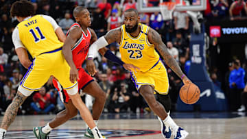 Feb 4, 2025; Inglewood, California, USA; Los Angeles Lakers forward LeBron James (23) moves the ball as center Jaxson Hayes (11) provides coverage against Los Angeles Clippers guard Kris Dunn (8) during the second half at Intuit Dome. Mandatory Credit: Gary A. Vasquez-Imagn Images