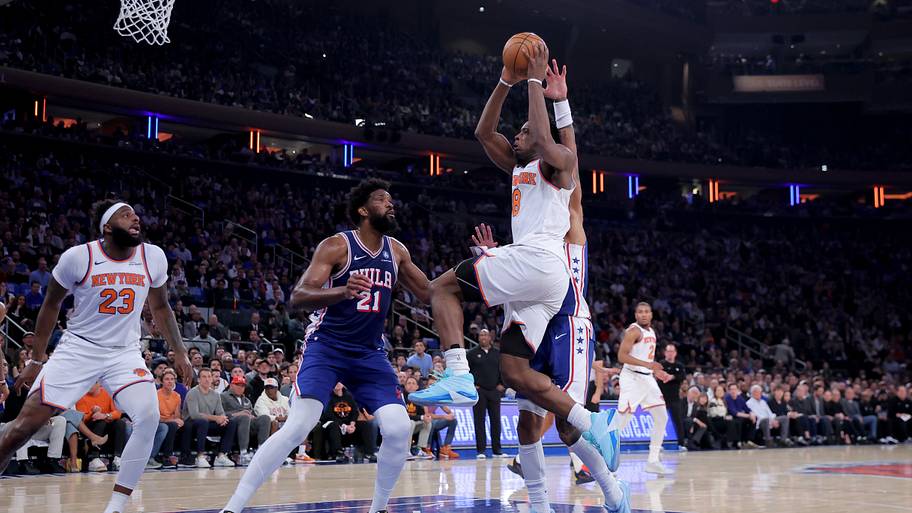 New York Knicks forward OG Anunoby drives to the basket against Philadelphia 76ers C Joel Embiid and F Kelly Oubre Jr.