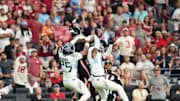 Arizona Cardinals receiver Marvin Harrison Jr. (18) makes a first-down catch over Tennessee Titans defenders Jalyn Armour-Davis (18) and Xavier Woods (25) at State Farm Stadium in Glendale on Oct. 5, 2025.