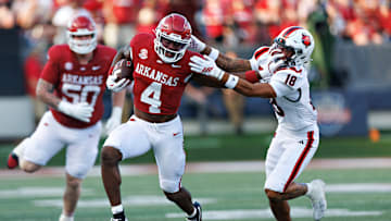 Arkansas Razorback senior tailback Mike Washington Jr. stiff arms Arkansas State safety Malekhi Weedon during Saturday's 56-14 Razorback win at War Memorial Stadium in Little Rock