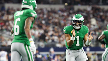 Eagles quarterback Jalen Hurts and wide receiver Devonta Smith interact on the sideline during Philadelphia's 24–21 loss to the Cowboys.