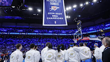 Oct 21, 2025; Oklahoma City, Oklahoma, USA; Oklahoma City Thunder team members watch as their NBA Championship banner rises before the start of a game against the Houston Rockets at Paycom Center. Mandatory Credit: Alonzo Adams-Imagn Images
