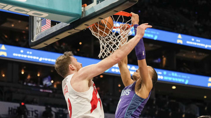 Apr 2, 2023; Charlotte, North Carolina, USA;  Charlotte Hornets guard Bryce McGowens (7) makes a dunk over Toronto Raptors center Jakob Poeltl (19) during second half at Spectrum Center. Mandatory Credit: Jim Dedmon-USA TODAY Sports