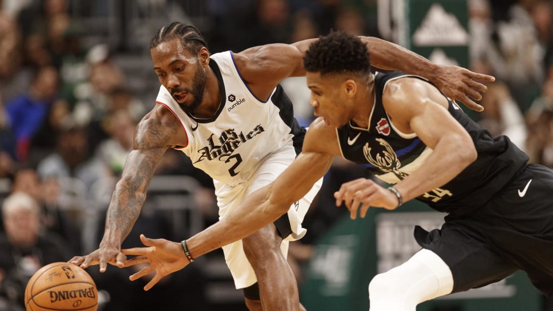 Dec 6, 2019; Milwaukee, WI, USA; Los Angeles Clippers forward Kawhi Leonard (2) and Milwaukee Bucks forward Giannis Antetokounmpo (34) reach for the loose ball during the third quarter at Fiserv Forum. Mandatory Credit: Jeff Hanisch-USA TODAY Sports