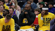 James smirks while sitting on the Lakers bench.