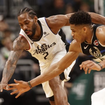 Dec 6, 2019; Milwaukee, WI, USA; Los Angeles Clippers forward Kawhi Leonard (2) and Milwaukee Bucks forward Giannis Antetokounmpo (34) reach for the loose ball during the third quarter at Fiserv Forum. Mandatory Credit: Jeff Hanisch-USA TODAY Sports