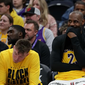 James smirks while sitting on the Lakers bench.