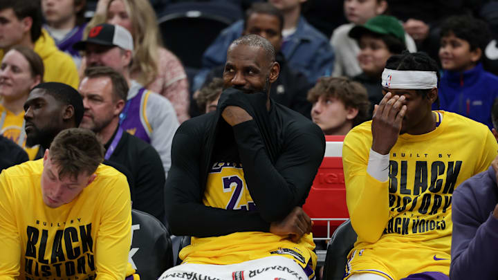 James smirks while sitting on the Lakers bench.