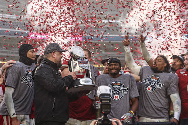 Nebraska head coach Matt Rhule holds the 2024 Pinstripe Bowl trophy as the team celebrates its win over Boston College.