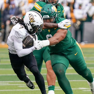Nov 1, 2025; Waco, Texas, USA; UCF Knights wide receiver Duane Thomas Jr. (7) is tackled by Baylor Bears defensive lineman Jackie Marshall (0) during the first half at McLane Stadium. Mandatory Credit: Raymond Carlin III-Imagn Images