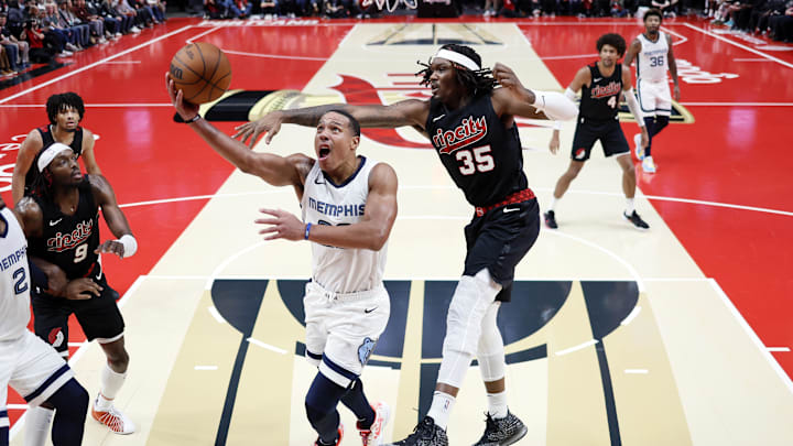 Nov 3, 2023; Portland, Oregon, USA; Memphis Grizzlies shooting guard Desmond Bane (22) drives to the basket under pressure from Portland Trail Blazers center Robert Williams III (35) during the second half at Moda Center. Mandatory Credit: Soobum Im-Imagn Images