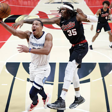 Nov 3, 2023; Portland, Oregon, USA; Memphis Grizzlies shooting guard Desmond Bane (22) drives to the basket under pressure from Portland Trail Blazers center Robert Williams III (35) during the second half at Moda Center. Mandatory Credit: Soobum Im-USA TODAY Sports