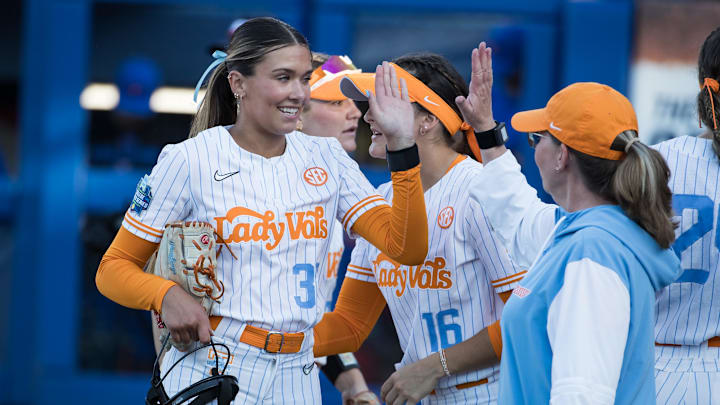 May 30, 2025; Oklahoma City, OK, USA;  Tennessee Lady Volunteers pitcher Erin Nuwer (33) slaps hands with head coach Karen Weekly in the fourth inning against the Florida Gators during the NCAA Softball Women's College World Series at Devon Park. Mandatory Credit: Brett Rojo-Imagn Images