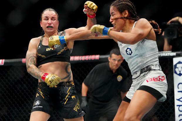 Raquel Pennington (red gloves) fights Julianna Pena (blue gloves) in a women’s bantamweight title bout during UFC 307.