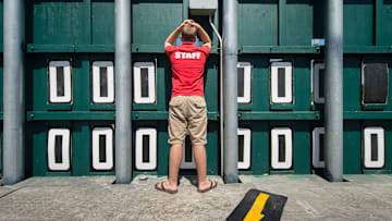 Scoreboard attendant Carl Steffens watches through a hole in the scoreboard in centerfield at Nat Bailey Stadium.