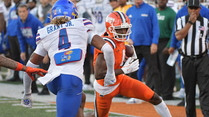 Sep 7, 2024; Champaign, Illinois, USA; Illinois Fighting Illini wide receiver Zakhari Franklin (4) runs for a first down as Kansas Jayhawks safety Marvin Grant (4) pursues during the first half at Memorial Stadium. Mandatory Credit: Ron Johnson-Imagn Images