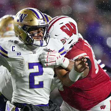 UW quarterback Demond Williams Jr. (2) throws the ball away under pressure from Wisconsin's Brandon Lane Jr. 