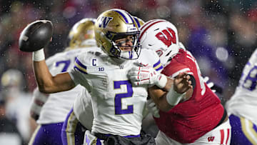 Nov 8, 2025; Madison, Wisconsin, USA;  Washington Huskies quarterback Demond Williams Jr. (2) throws the ball away under pressure from Wisconsin Badgers defensive lineman Brandon Lane Jr. (95) during the third quarter at Camp Randall Stadium. Mandatory Credit: Jeff Hanisch-Imagn Images