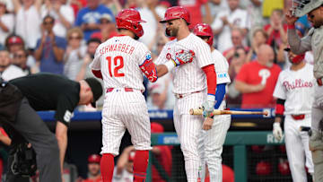 Philadelphia Phillies designated hitter Kyle Schwarber reacts with Bryce Harper against the Boston Red Sox during MLB game