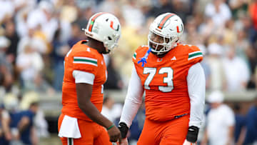 Nov 9, 2024; Atlanta, Georgia, USA; Miami Hurricanes quarterback Cam Ward (1) and offensive lineman Anez Cooper (73) celebrates after a touchdown against the Georgia Tech Yellow Jackets in the first quarter at Bobby Dodd Stadium at Hyundai Field. Mandatory Credit: Brett Davis-Imagn Images
