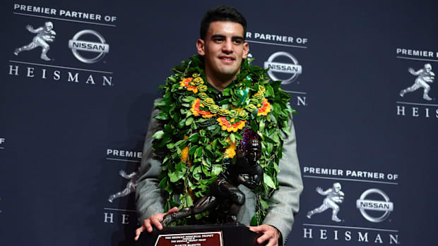 Oregon Ducks quarterback Marcus Mariota poses with the Heisman Trophy during a press conference at the New York Marriott Marq