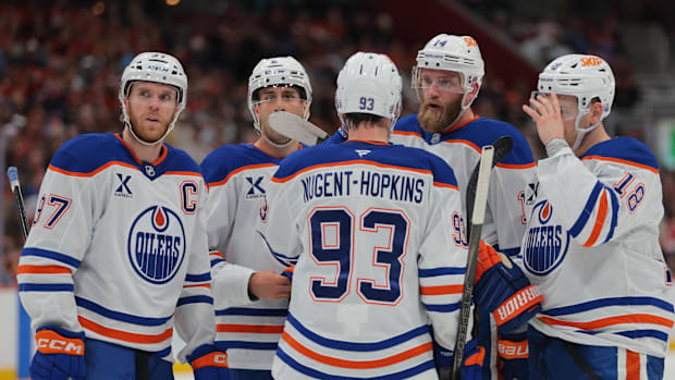 Edmonton Oilers defenseman Mattias Ekholm talks to center Connor McDavid and teammates.