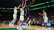 Nov 12, 2025; Boston, Massachusetts, USA; Memphis Grizzlies forward Olivier-Maxence Prosper (18) goes to the basket past Boston Celtics center Luka Garza (52) during the first quarter at TD Garden. Mandatory Credit: Winslow Townson-Imagn Images