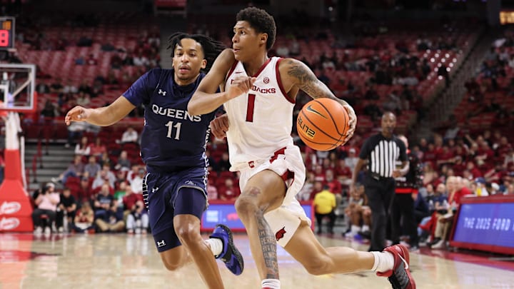 Dec 16, 2025; Fayetteville, Arkansas, USA; Arkansas Razorbacks guard Meleek Thomas (1) drives against Queens Royals guard Chris Ashby (11) during the second half at Bud Walton Arena. Arkansas won 108-80. Mandatory Credit: Nelson Chenault-Imagn Images