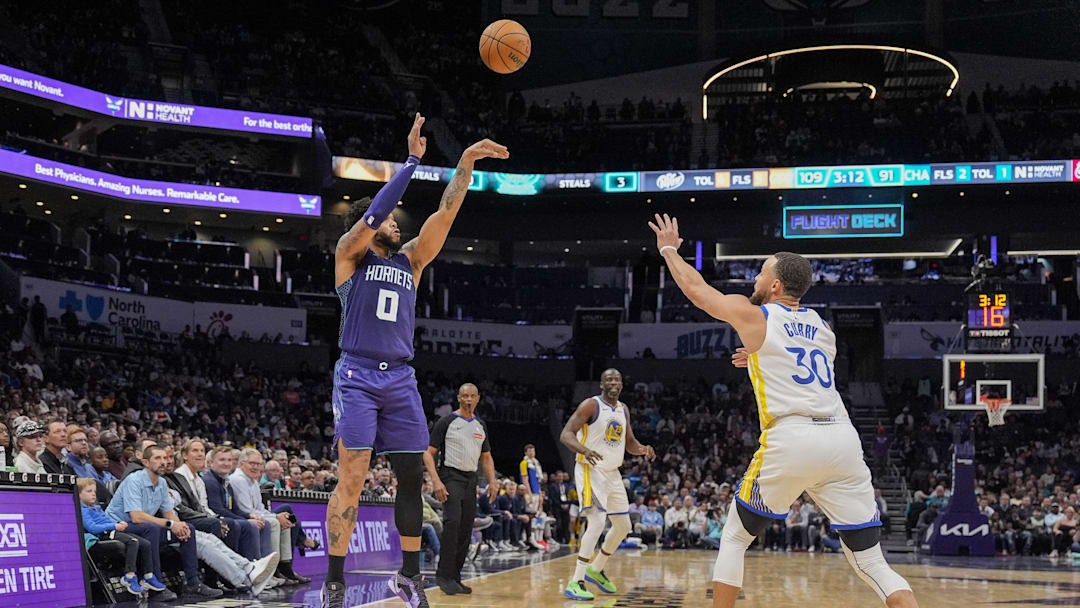 Mar 3, 2025; Charlotte, North Carolina, USA; Charlotte Hornets forward Miles Bridges (0) shoots over Golden State Warriors guard Stephen Curry (30) from three during the second half at Spectrum Center. Mandatory Credit: Jim Dedmon-Imagn Images