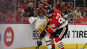 Apr 6, 2025; Chicago, Illinois, USA; Chicago Blackhawks center Joe Veleno (90) and Pittsburgh Penguins defenseman Ryan Shea (5) battle for control of the puck during the first period at United Center. Mandatory Credit: Talia Sprague-Imagn Images