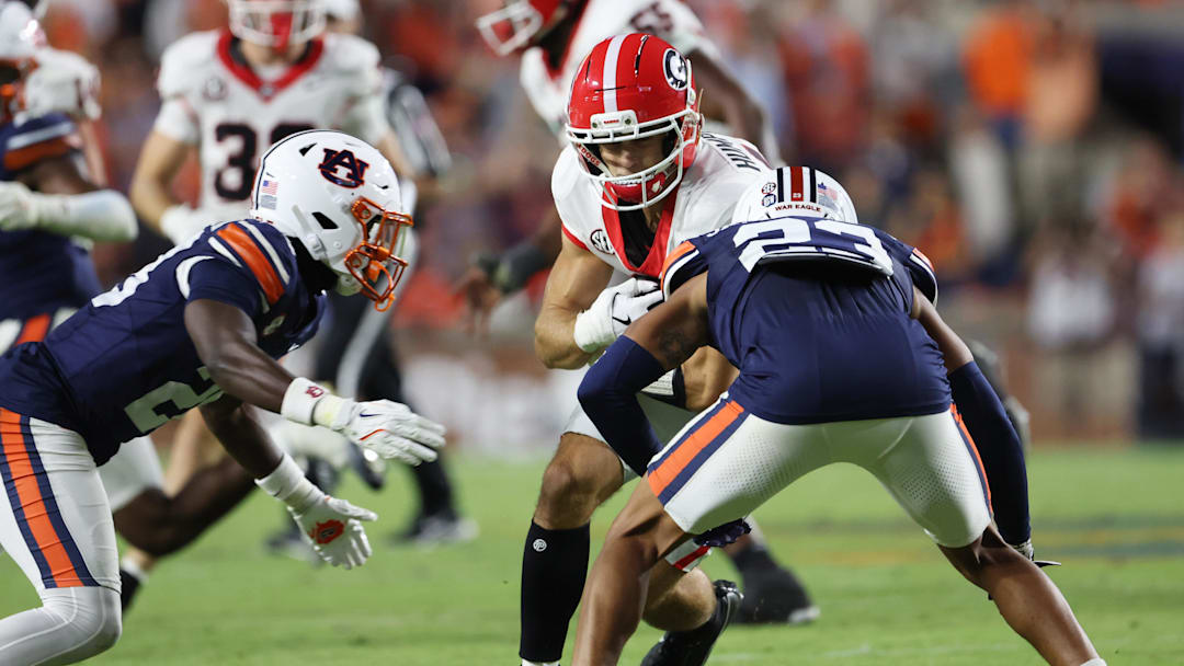 Oct 11, 2025; Auburn, Alabama, USA;  Auburn Tigers defensive back Kensley Louidor-Faustin (28) and cornerback Jay Crawford (23) close in on Georgia Bulldogs wide receiver London Humphreys (16) during the fourth quarter at Jordan-Hare Stadium. Mandatory Credit: John Reed-Imagn Images