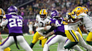 Green Bay Packers running back Josh Jacobs (8) looks for room to run against Minnesota Vikings safety Josh Metellus (44) during their football game Sunday, December 29, 2024, at U.S. Bank Stadium in Minneapolis, Minnesota.