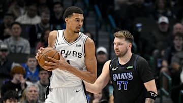 Feb 14, 2024; Dallas, Texas, USA; San Antonio Spurs center Victor Wembanyama (1) looks to move the ball past Dallas Mavericks guard Luka Doncic (77) during the fist quarter at the American Airlines Center. Mandatory Credit: Jerome Miron-Imagn Images