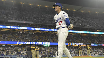Jun 19, 2025; Los Angeles, California, USA;   Los Angeles Dodgers designated hitter Shohei Ohtani (17) laughs the San Diego Padres dugout while at first base after he was hit by a pitch in the ninth inning at Dodger Stadium. Mandatory Credit: Jayne Kamin-Oncea-Imagn Images