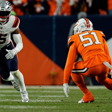 Dec 24, 2023; Denver, Colorado, USA; New England Patriots running back Ezekiel Elliott (15) runs the ball as Denver Broncos defensive end Ronnie Perkins (51) defends in the first quarter at Empower Field at Mile High. Mandatory Credit: Isaiah J. Downing-Imagn Images