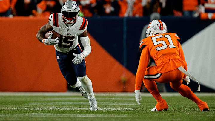 Dec 24, 2023; Denver, Colorado, USA; New England Patriots running back Ezekiel Elliott (15) runs the ball as Denver Broncos defensive end Ronnie Perkins (51) defends in the first quarter at Empower Field at Mile High. Mandatory Credit: Isaiah J. Downing-Imagn Images