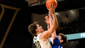 Jan 25, 2025; Nashville, Tennessee, USA;  Vanderbilt Commodores guard Chris Manon (30) shoots over  Kentucky Wildcats forward Trent Noah (9) during the first half at Memorial Gymnasium. Mandatory Credit: Steve Roberts-Imagn Images