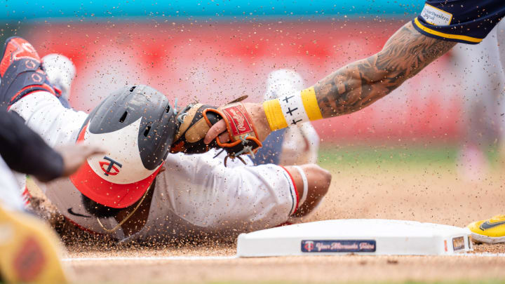 Jul 21, 2024; Minneapolis, Minnesota, USA; Minnesota Twins shortstop Willi Castro (50) slides, trying for a triple and is tagged out by Milwaukee Brewers third base Joey Ortiz (3) in the first inning at Target Field. Mandatory Credit: Matt Blewett-USA TODAY Sports