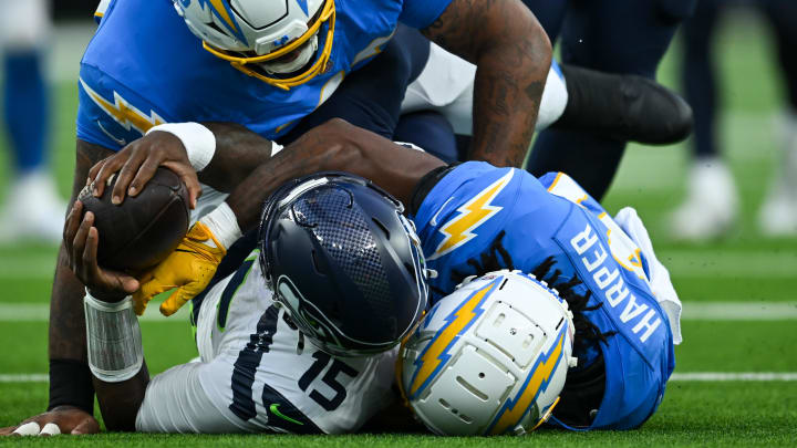 Aug 10, 2024; Inglewood, California, USA; Seattle Seahawks quarterback PJ Walker (15) is sacked by Los Angeles Chargers defensive tackle Jerrod Clark (72) and safety Thomas Harper (41) during the fourth quarter at SoFi Stadium. Mandatory Credit: Jonathan Hui-USA TODAY Sports