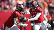 Nov 30, 2025; Tampa, Florida, USA; Tampa Bay Buccaneers quarterback Baker Mayfield (6) hands off to running back Rachaad White (1) during the first half against the Arizona Cardinals at Raymond James Stadium. Mandatory Credit: Nathan Ray Seebeck-Imagn Images