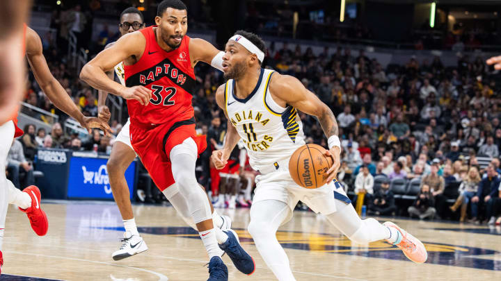 Nov 22, 2023; Indianapolis, Indiana, USA; Indiana Pacers forward Bruce Brown (11) dribbles the ball while Toronto Raptors forward Otto Porter Jr. (32) defends in the second half at Gainbridge Fieldhouse. Mandatory Credit: Trevor Ruszkowski-USA TODAY Sports