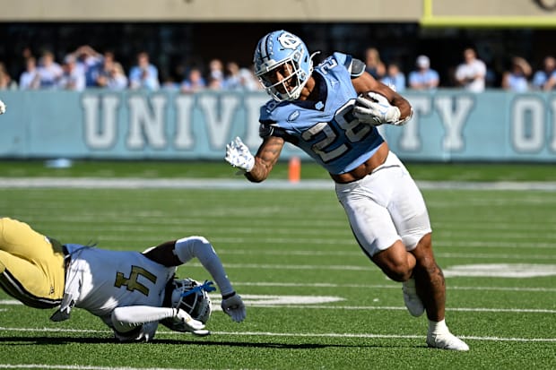 North Carolina Tar Heels running back Omarion Hampton runs the ball past Georgia Tech Yellow Jackets defender.