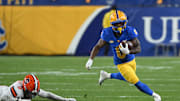 Oct 24, 2024; Pittsburgh, Pennsylvania, USA; Pittsburgh Panthers running back Desmond Reid (0) eludes Syracuse Orange defensive back Duce Chestnut (0) during the first quarter  at Acrisure Stadium. Mandatory Credit: Barry Reeger-Imagn Images