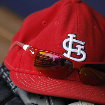 Jul 27, 2013; Atlanta, GA, USA; Detailed view of St. Louis Cardinals cap and glove in the dugout before a game against the Atlanta Braves at Turner Field. Mandatory Credit: Brett Davis-Imagn Images