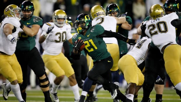 Oregon's LaMichael James breaks through the UCLA line on his way to a first quarter touchdown on the first drive for the Duck