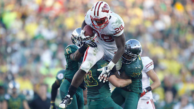 Wisconsin Badgers Montee Ball gains 13-yards against the Oregon Ducks Ifo Ekpre-Olomu