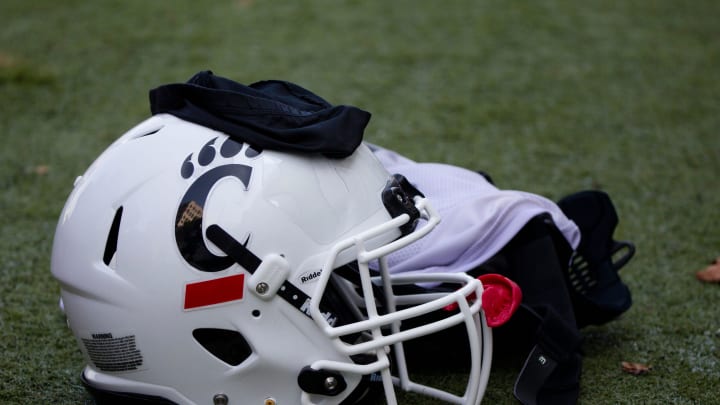 A Cincinnati Bearcats helmet and gloves sits on the turf during Cincinnati Bearcats football practice Wednesday, July 31, 2019, at the University of Cincinnati. 

Cincinnati Bearcats 107